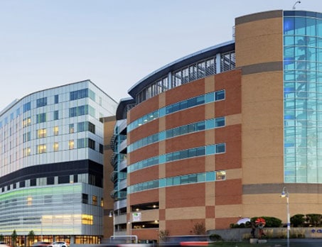 Modern medical building with glass and brick facade in an urban setting.
