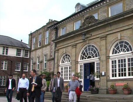 Modern medical clinic building exterior with patients and staff.